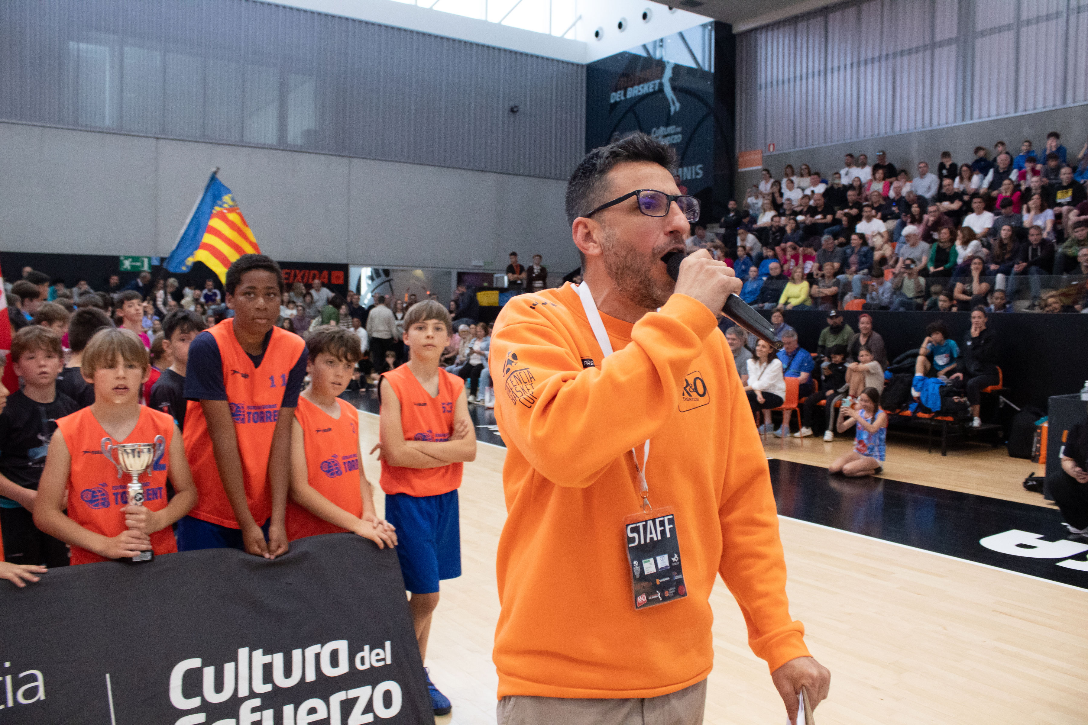Presentador con el público al fondo